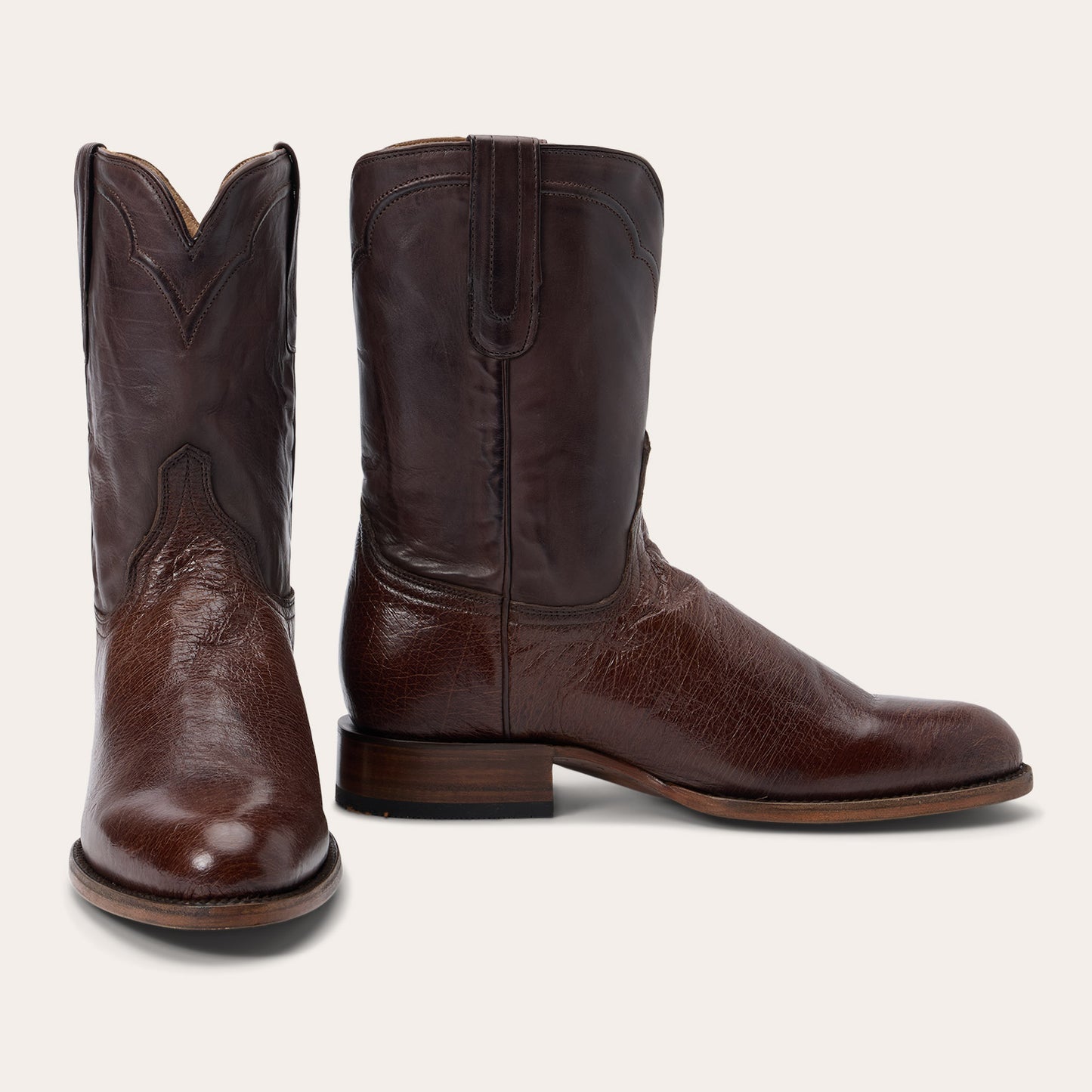 The Mens Stetson Clay Ostrich Boots by Stetson Boots feature handcrafted brown leather, a round toe, low stacked heel, and decorative shaft stitching, displayed against a white background.