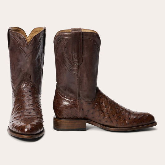 The Mens Stetson Austin Ostrich Boots by Stetson Boots feature a handcrafted round toe, brown ostrich leather with dimpled texture, a smooth shaft with decorative stitching, low heel, and convenient pull tabs.