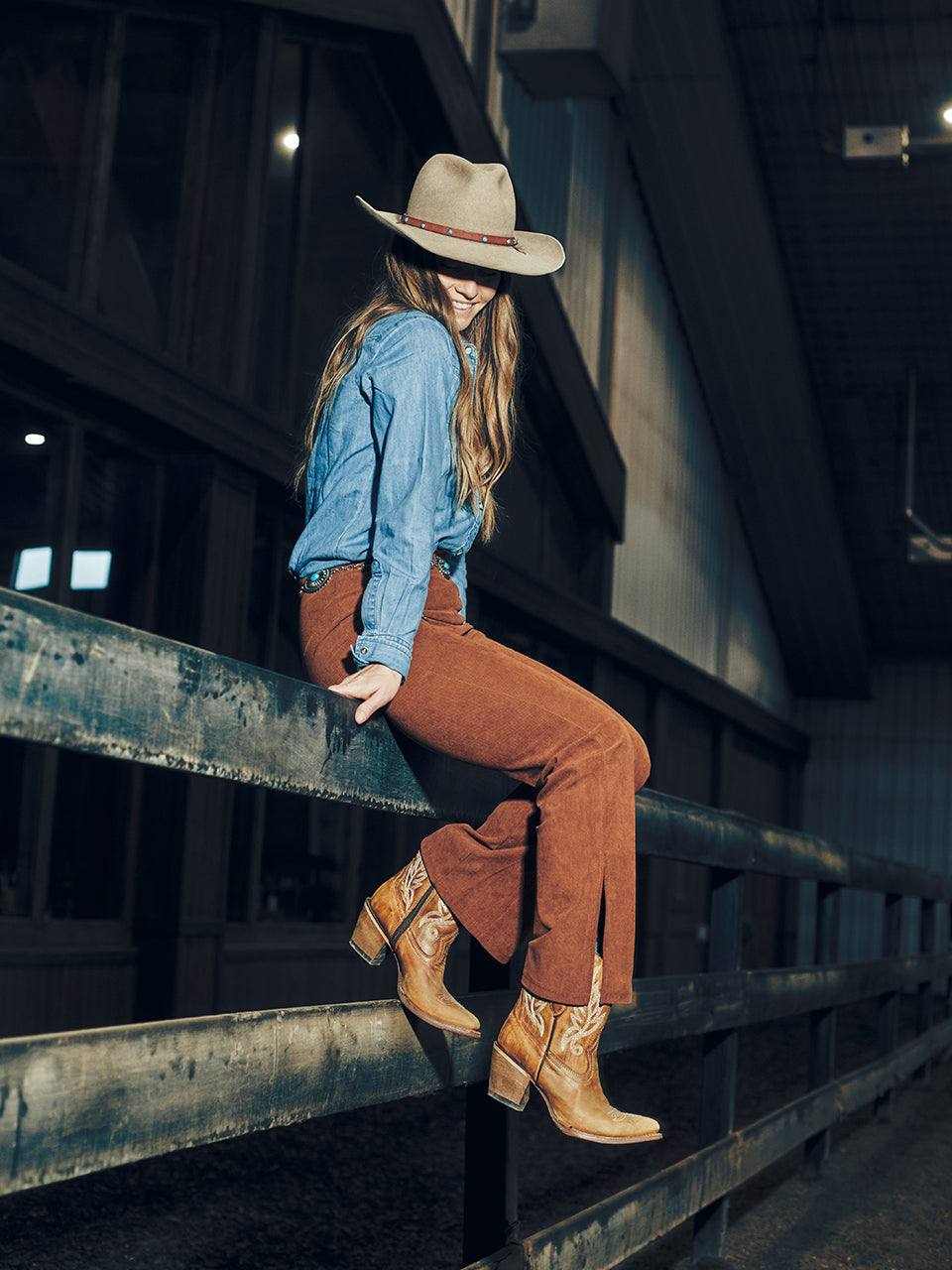 Women's Corral Tan Leather Ankle Boots with Embroidery featuring tan leather, detailed stitching, and a stacked heel worn with brown pants and a denim shirt