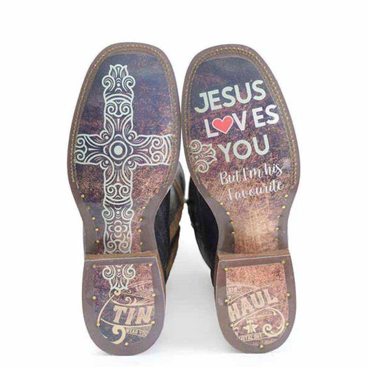 Women's Tin Haul Boots with brown leather soles, ornate cross artwork, and colorful Jesus-themed lettering and heel logos