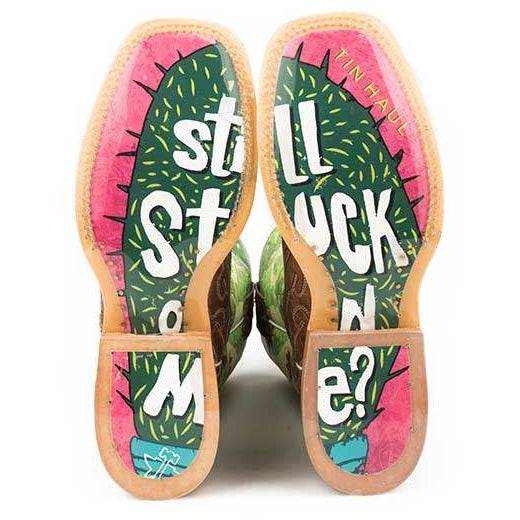 Women's Tin Haul cowboy boots with colorful cactus-print soles, pink borders, tan edges, and bold white lettering