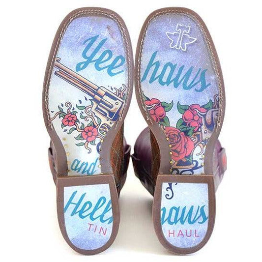 Women's Tin Haul Boots with brown leather soles, blue lettering, floral artwork, a cross, and pistol graphic