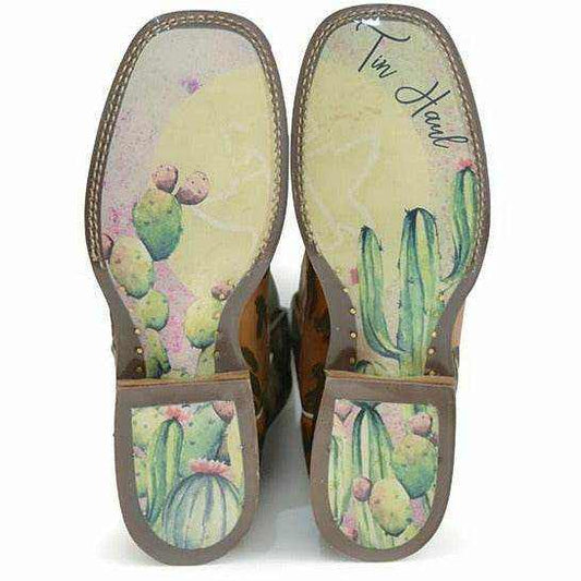 Women's Tin Haul Cactaplicity Boots with tan leather soles, colorful hand-painted cactus designs, and brown stitched edging